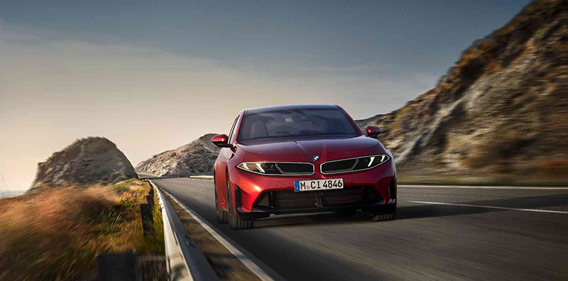 BMW Série i3 rouge sur une route de montagne