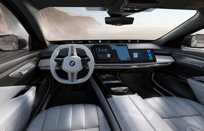 Poste de conduite de la BMW Série 7 2026 avec le BMW Panoramic iDrive, le volant multifonction futuriste et la bande lumineuse d'ambiance interactive.