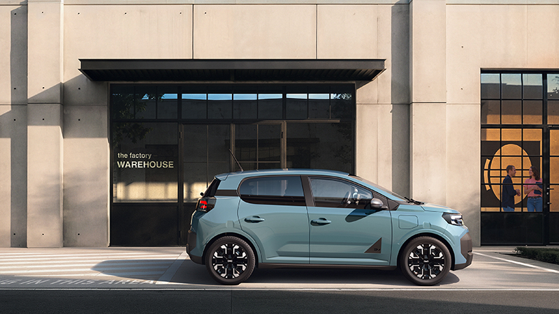 Nouvelle Dacia Spring verte en face d'un bâtiment