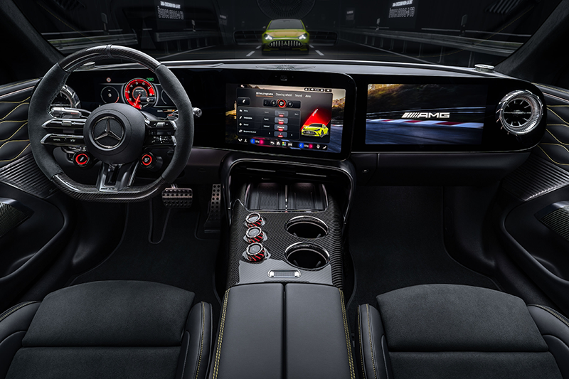 Plan large du tableau de bord de la Mercedes-AMG GT électrique, montrant le volant sport en Alcantara, la triple dalle d'écrans numériques avec affichage tubulaire rouge et la console centrale en carbone.