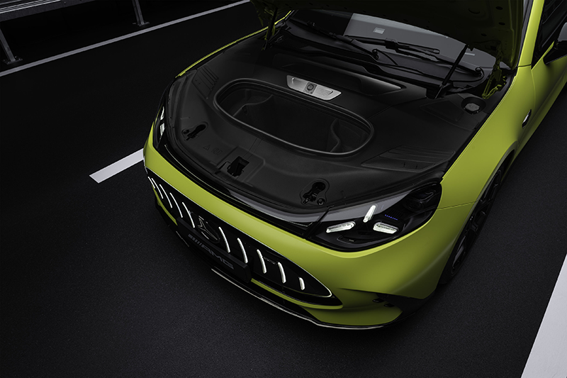 Vue plongeante sur le frunk ouvert de la Mercedes-AMG GT Coupé 4 portes électrique jaune, révélant l'espace de rangement sous le capot avant.