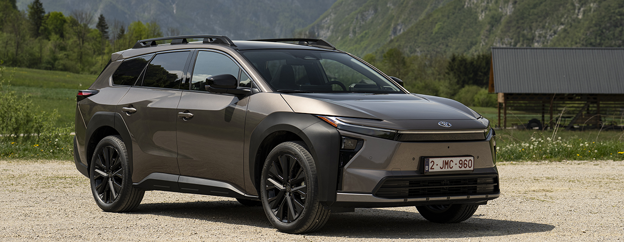 SUV électrique Toyota bZ4X Touring 2026 coloris Brilliant Bronze Metallic en version AWD, jantes noir mat, sur un chemin de montagne