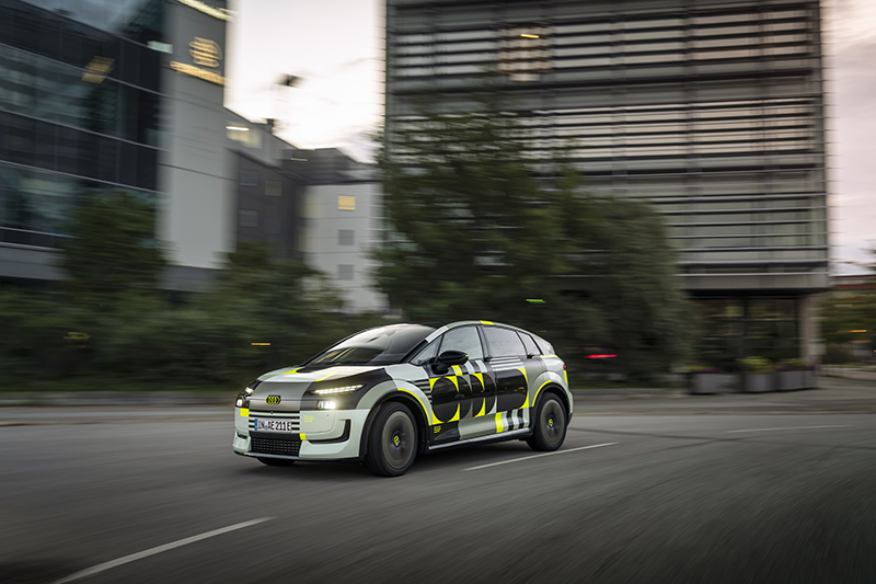 Audi A2 e tron en ville devant des bâtiments