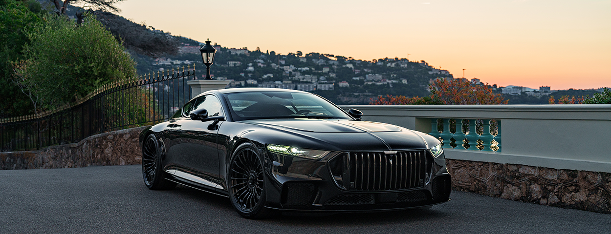 Supercar BRABUS BODO de couleur noire garée sur les hauteurs de Monaco au coucher du soleil, vue sur la face avant et les jantes forgées Monoblock Z-GT.