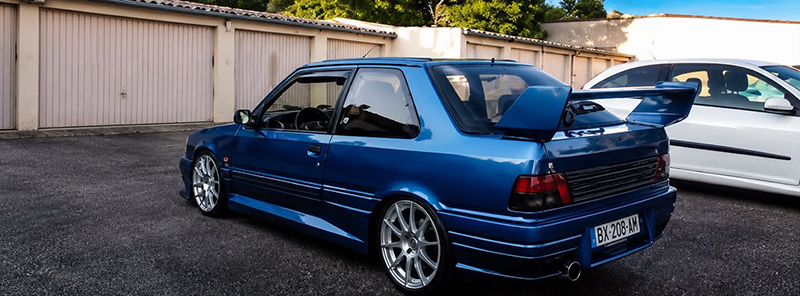 309 GTI bleue face aux garages